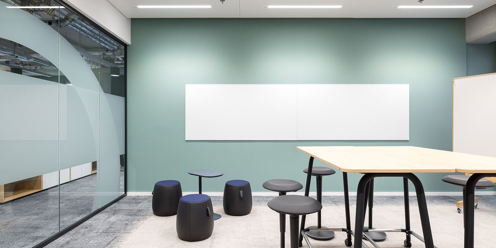 Modern meeting room with se:lab high desk workshop table, se:fit standing seats and universal se:dot stools for agile working and collaboration.
