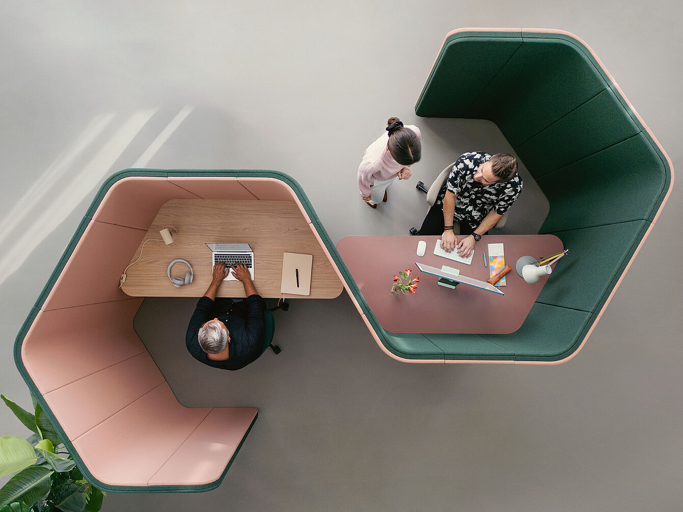 Due persone che lavorano in pod adiacenti esagonali se:hive, una con un laptop e l’altra con un computer desktop, visti dall’alto